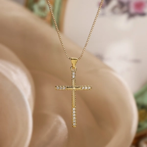 Macro shot of 18K gold plated cross pendant with shimmering pavé zircon details
