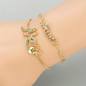 Close-up of gold-plated bracelets featuring MAMA and Mom charms with colorful cubic zirconia