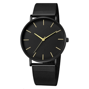 Detail of minimalist black quartz watch with gold markers and black Milanese mesh strap
