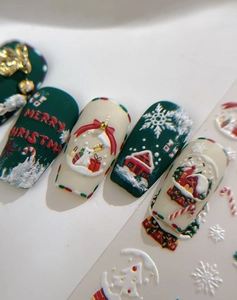 Vue macro de stickers 3D gaufrés pour ongles de Noël avec flocons et motifs de maisonnette