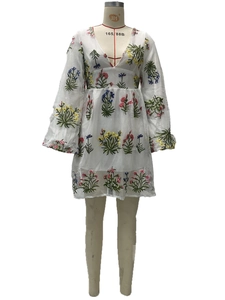 Detail der bunten Blumenstickerei und Laternärmeln am weißen Feen-Netzkleid