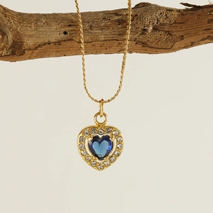 Elegant gold heart necklace with a blue gemstone and sparkling zircon crystals on a branch