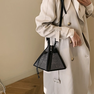 Elegant pyramid evening bag with silver rhinestones on black leather, handheld by model