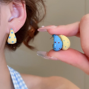 Detail of water drop earrings in yellow blue and blue red polka dot enamel finish
