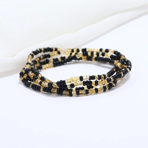 Detailed macro view of double-layered black and amber glass seed beads waist chain