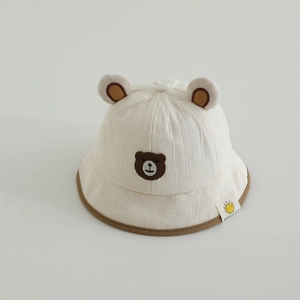 Détail d'un chapeau pour bébé crème avec oreilles d'ours et liseré marron doux