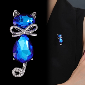 Elegant cat brooch featuring deep blue crystals and rhinestones on a black suit lapel