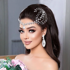 Detail of silver bridal headband with crystal vine design and teardrop stone with earrings