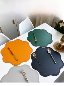 Detail of flower-shaped faux leather placemats in multiple colors with wavy petal edges