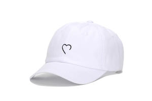 Gros plan sur la broderie cœur d'une casquette de baseball en toile de coton blanc