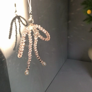 Detail of pink crystal bow phone charm with a metal star pendant and pearl beads