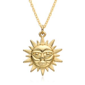 Detailed macro view of the gold-plated celestial sun pendant with human face details