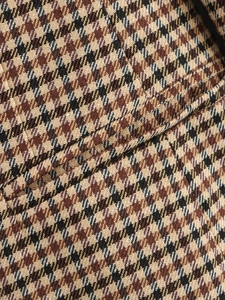 Κοντινό πλάνο υφής υφάσματος houndstooth σε καφέ και μαύρο για σακάκι μπλέιζερ