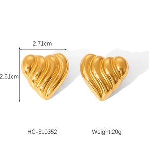 Macro shot showing dimensions of textured gold heart earrings, 2.71cm wide and 2.61cm high