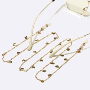 Detail of golden eyeglass chain with shell charms and adjustable silicone loops