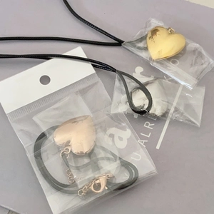 Polished stainless steel heart locket pendants in gold, silver, and rose gold with cords