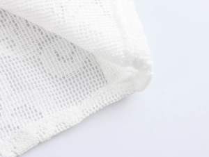 Close-up of white mesh fabric texture and high-quality edge stitching for elegant dresses