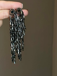 Detailed close-up showing the shimmering gunmetal sequins on long fringe earrings
