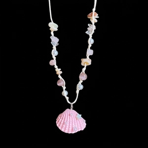 Détail du collier de plage perlé avec pendentif coquillage rose et cordon blanc