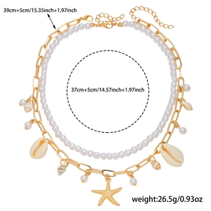 Detail of layered gold chain necklace with starfish, shell charms, and faux pearls