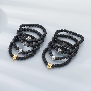 Black lava stone 8mm bead bracelet featuring golden and silver metal animal head charms