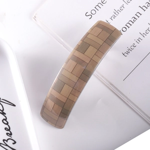 Detail of checkered brown acetate hair clip with vintage wood grain pattern textures