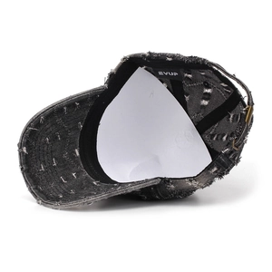 Detailed view of vintage washed denim baseball cap with distressed hole and metal buckle