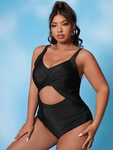 Detail of classic black one-piece swimsuit with crossover pleats and cutout design