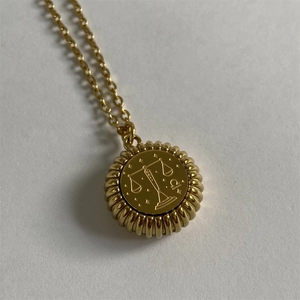 Macro detail of golden Libra zodiac pendant with celestial stars and radiant texture