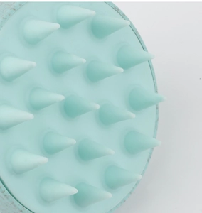Close-up of mint green silicone scalp massage brush with 19 conical bristles