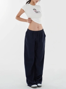 Detail of white cat print cropped T-shirt paired with dark blue wide leg casual trousers