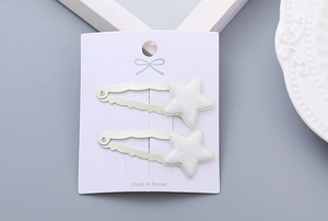 Macro view of glittering star hair clips set on white card with Korean text detail