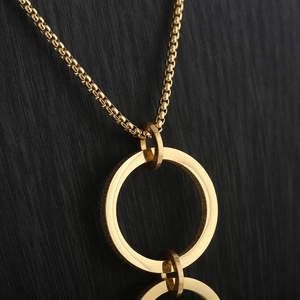 Macro shot of gold interlocking circles pendant on a fine titanium steel necklace