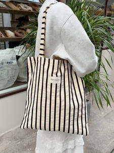 Large striped canvas tote bag with woven texture and vertical black and white lines