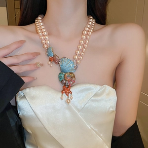 Detailed view of layered pink pearl necklace with shell and starfish pendants