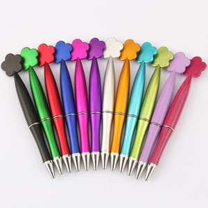 Set of 12 colorful metal ballpoint pens with creative flower top design on white background