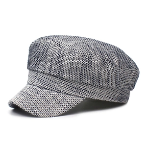 Close-up of gray tweed newsboy cap showing detailed woven fabric and retro military style