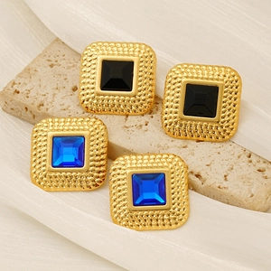 Detailed close-up of square vintage gold earrings with blue and black gemstones