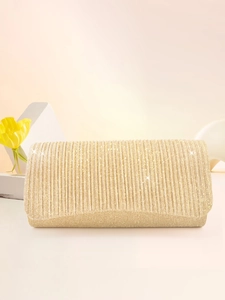Close-up of gold pleated evening clutch bag with glitter texture on beige stand