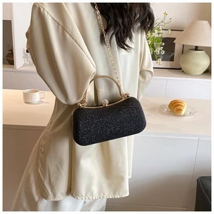 Detail of elegant black glitter evening bag with gold chain and rhinestone clasp