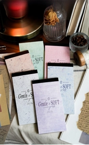 Detail of vintage style scrapbooking papers with textured fibers and soft pastel colors