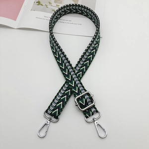 Detail of adjustable green and black herringbone woven strap with silver metal buckles