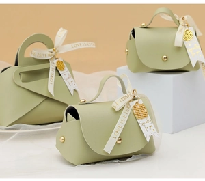 Detail of sage green faux leather gift bag with gold rivets and LOVE IS ETERNAL ribbon