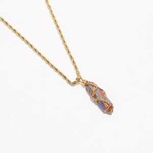 Detailed 45-degree close-up of gold twist chain and striped prism stone pendant