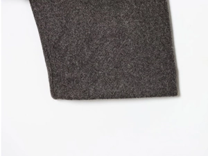 Macro shot of dark grey wool fabric texture on a minimalist bomber jacket detail