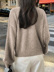 Détail du dos du pull en maille kaki montrant la texture douce et les manches longues unis