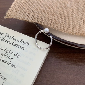 Detail of S925 sterling silver ring with a white pearl on a vintage book background