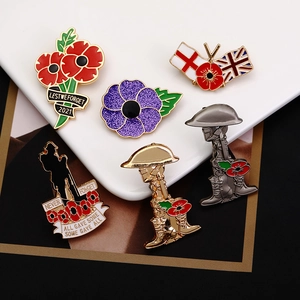 Detail of red and purple poppy enamel pins with Lest We Forget military silhouettes