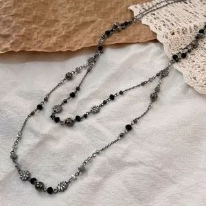 Double-layered beaded necklace with black crystals and metallic flower accents