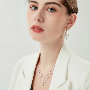 Close-up of 925 silver cross and star pendant necklace with sparkling zircon stones